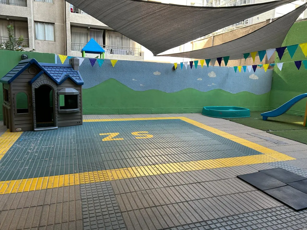 Patio de juegos con casita y resbalín